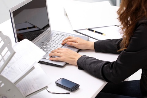 Plan en plongée d'une femme travaillant sur son ordinateur portable