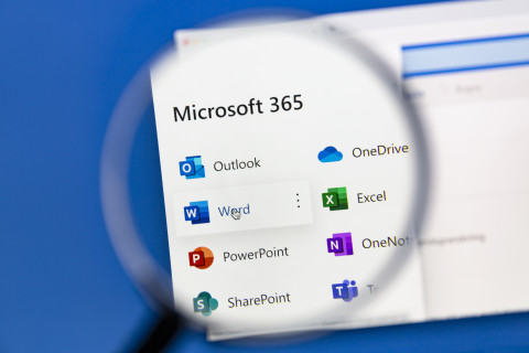 Vue d'une loupe pointant le logo office 365 devant un écran