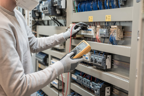 Vue d'un personne manipulant un multimetre