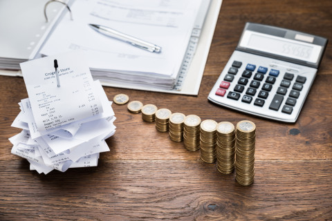 Vue d'un table avec de la monnaie, des factures et une calculatrice