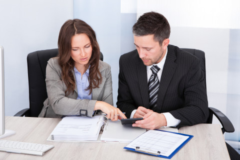 Vue de 2 personne qui analyse un document