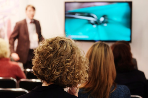 Vue d'une personne de loin qui présente un projet 